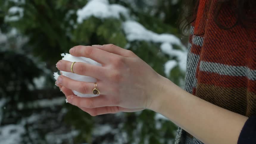 A woman has a snowball in her hands