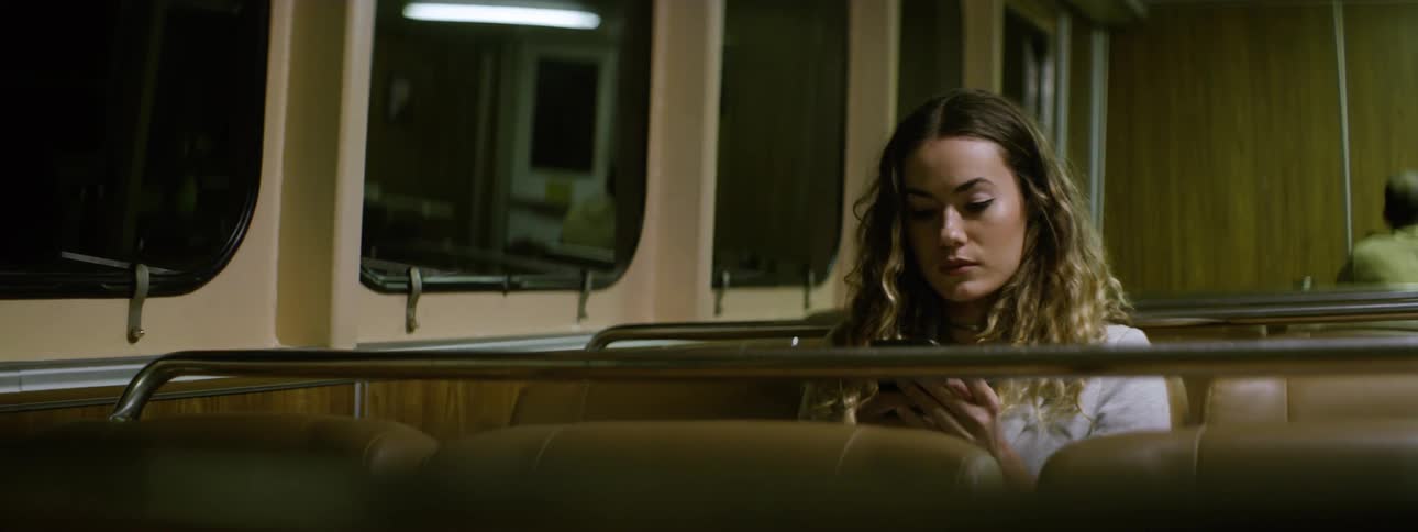 A woman plays with her phone on the bus