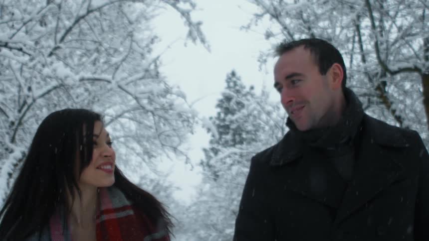 A man and woman are talking and walking in the snow