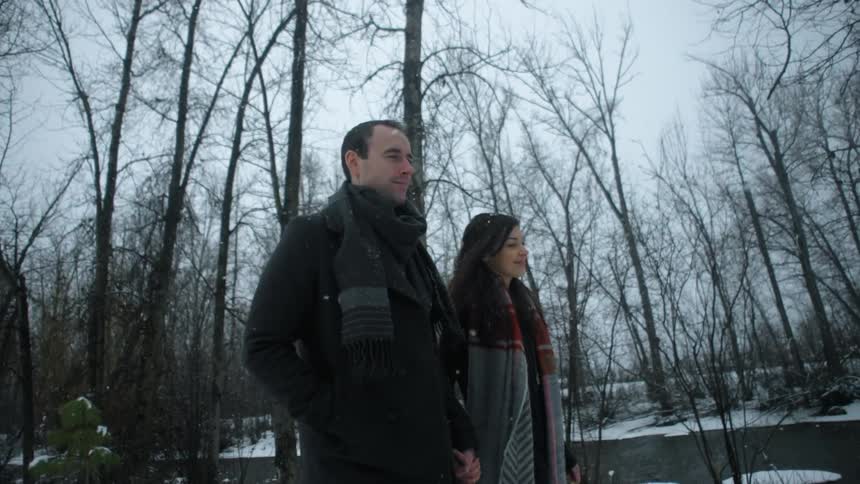 Couple walking along well holding hands in the snowy wilderness