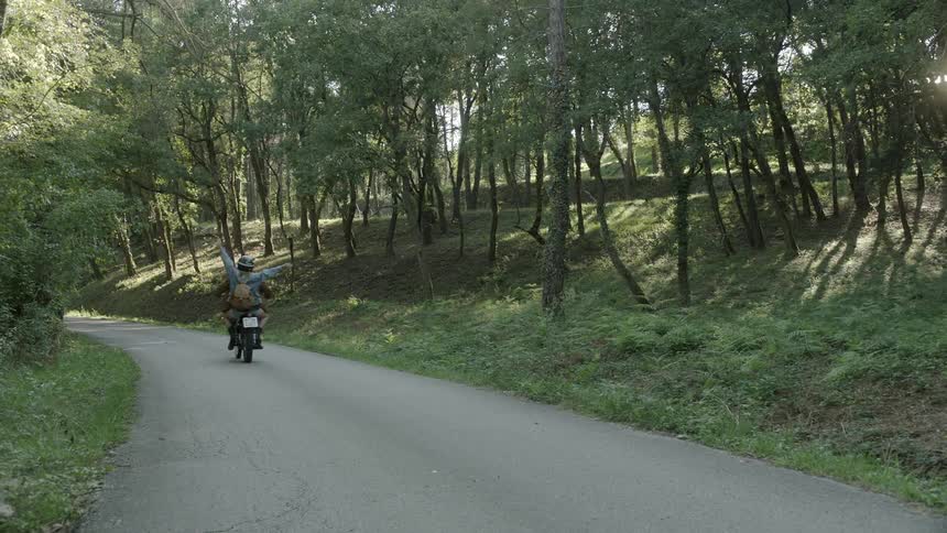 People ride down a small road on a bike