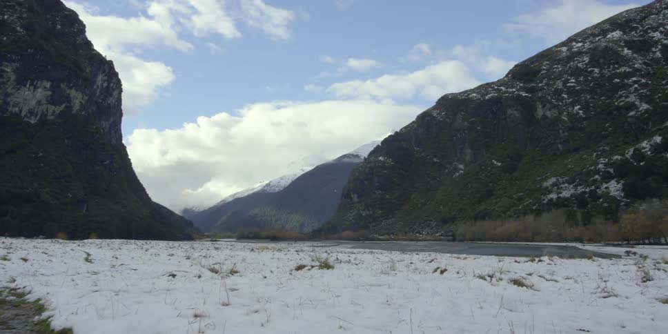 Large field covered with snow with large mountains up ahead