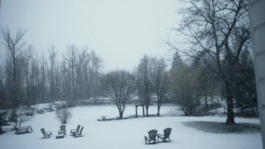 Snow falling on outdoor lawn furniture