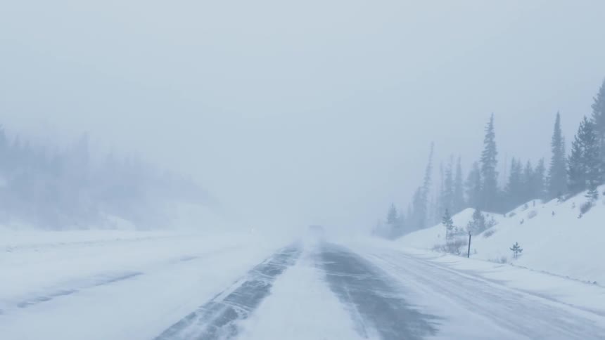 The pavement is barely visible on a snow covered highway