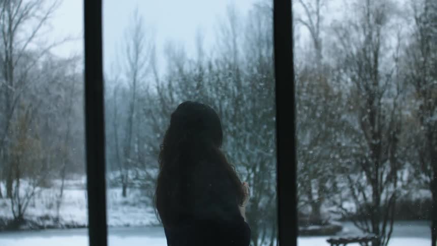 A woman stands outside on a snowy day