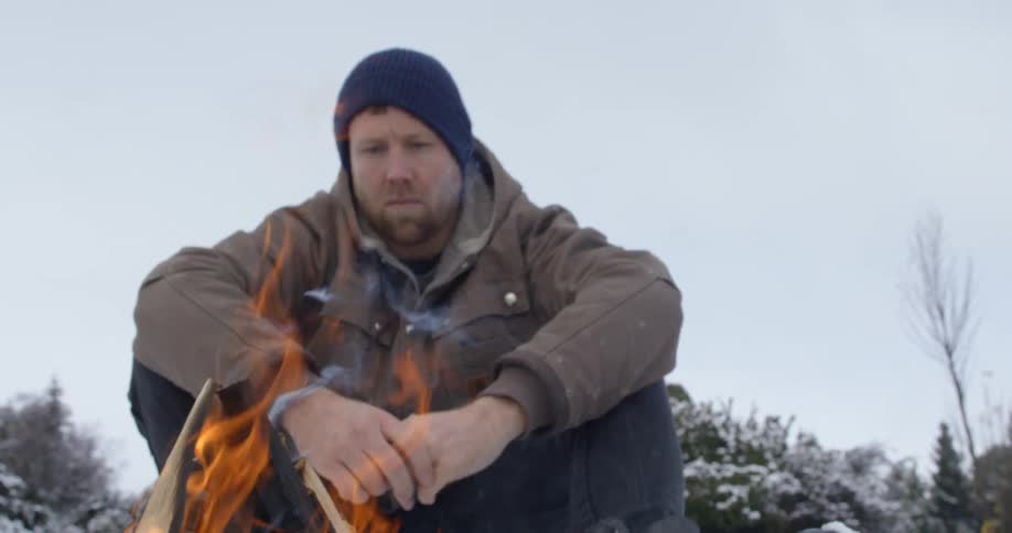 A person sitting next to a campfire