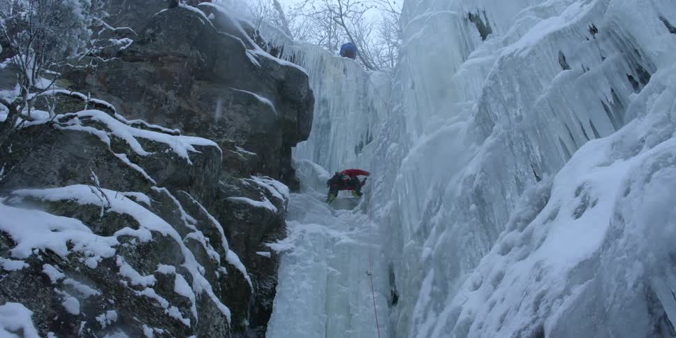 A man is repelling down an ice waterfall