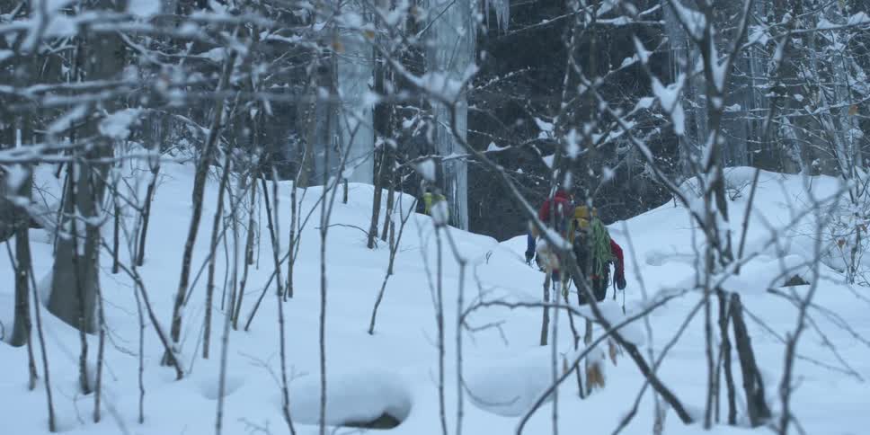 Two people hike through the snow