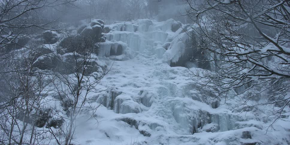 A frozen waterfall is shown from the bottom