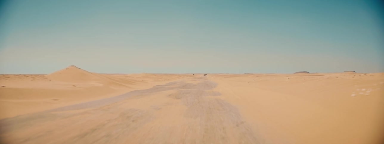 Moving across a desert under a clear sky