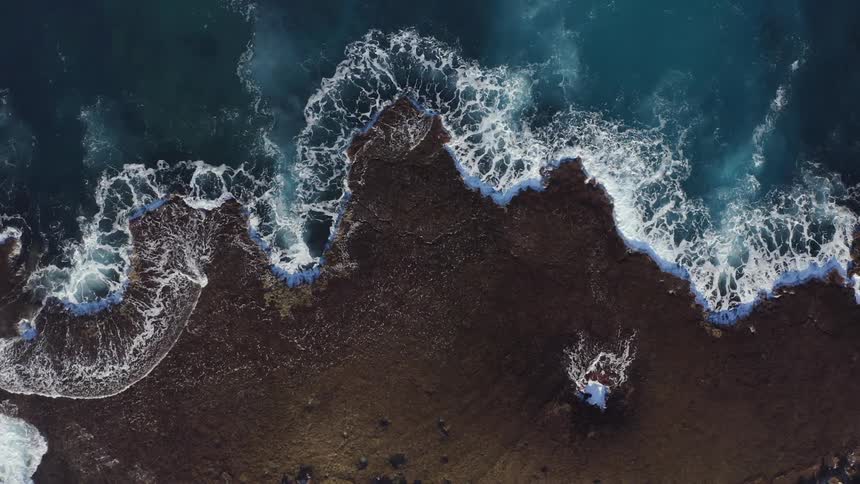 The ocean surface ripples and foams as waves come to shore