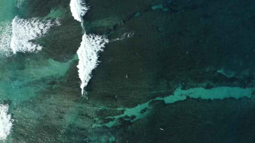 An aerial view of the ocean with waves