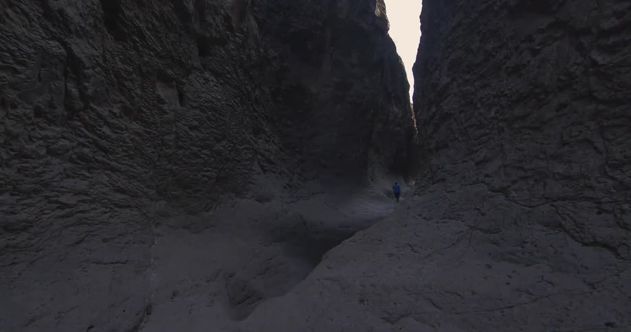 Hiking through a black sand covered canyon