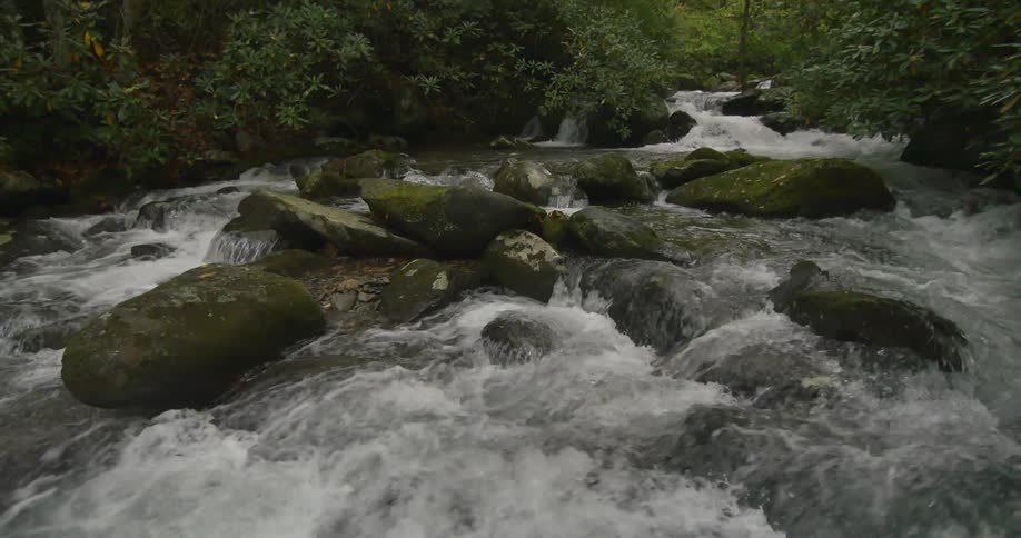 River water flows over large boulders in the wilderness