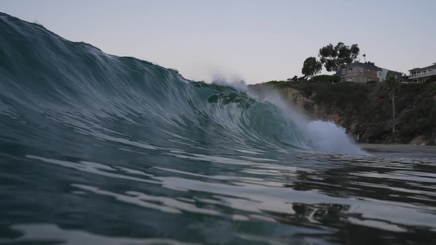 An ocean wave curls and breaks as it comes to shore