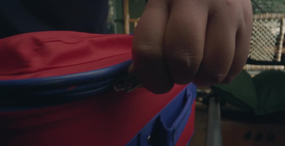 Person zipping up suitcase