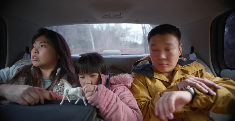 A family sitting in the back of a car