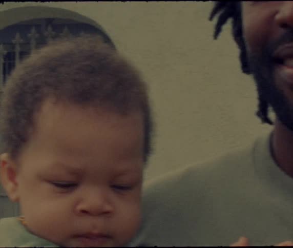 A man holding a small baby smiles