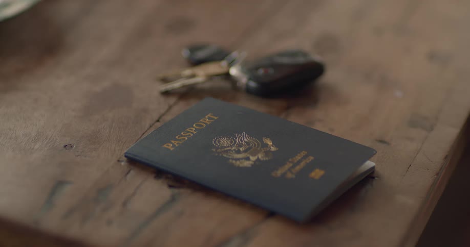 Mans hands take passport and car keys from table