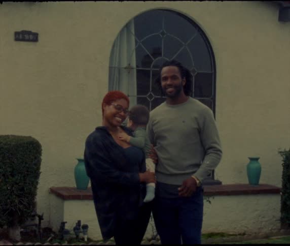 A mother father and baby standing outdoors