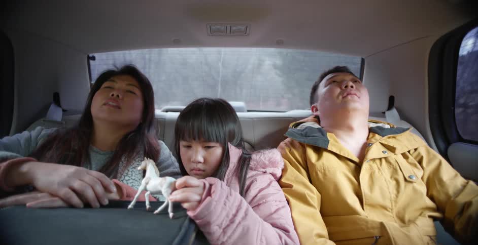 Tired family traveling on the back seat of a car wakes up and ask the driver to stop