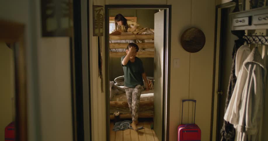 A mother rushes to awaken her children as they are all running late for something in the daytime
