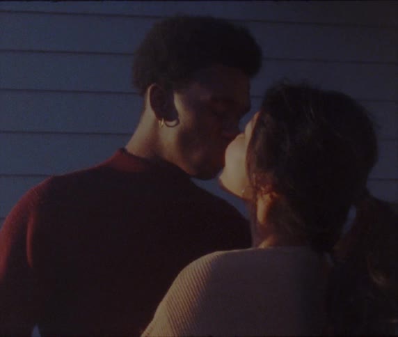 A couple kiss in the dark