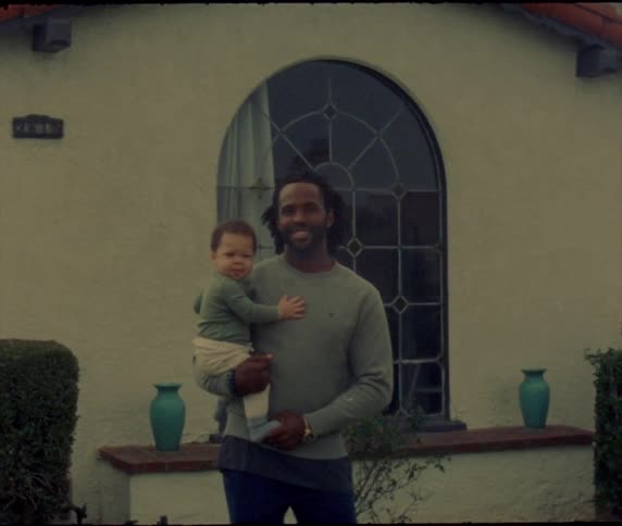 A father and son stand by the house