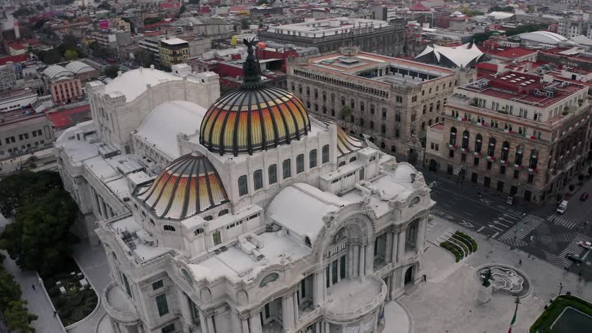 Foot and vehicle traffic pass by Palacio de Bellas Artes in downtown Mexico City