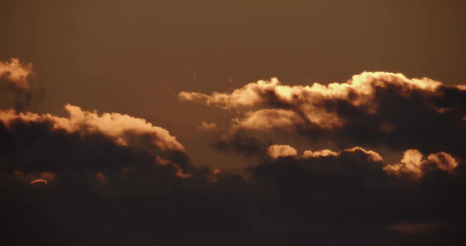 Sunlight shines through dark clouds in the sky
