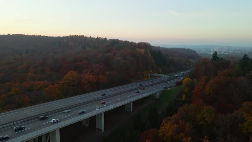 Heavy traffic heads toward downtown on an elevated highway surrounded by trees