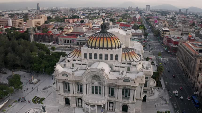Vehicles travel on the road past the Palacio de Bellas Artes in Mexico City