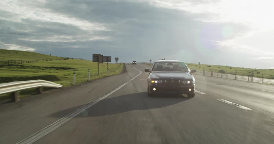 A vehicle gets off at an exit along a rural highway