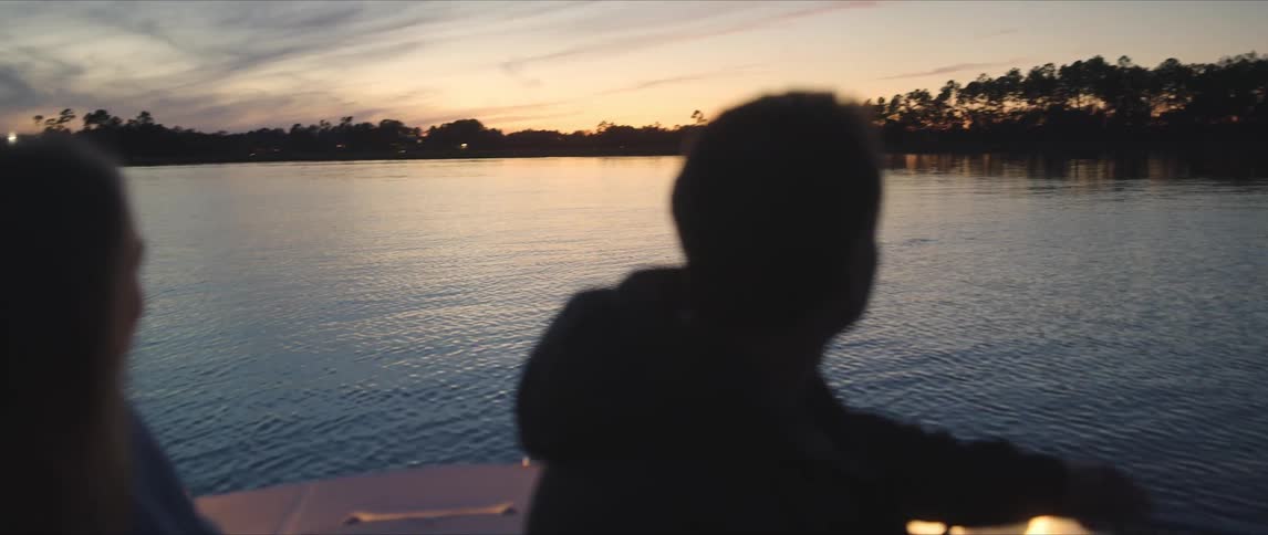A man and woman out on a small boat on a lake