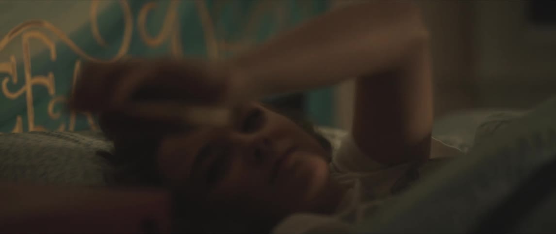 A view of a woman laying in a bed with a smartphone