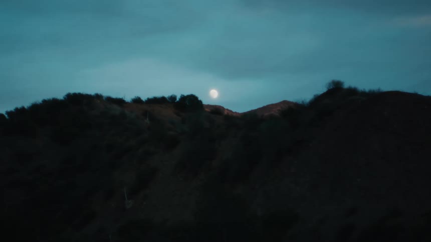 The moon is above a mountain range