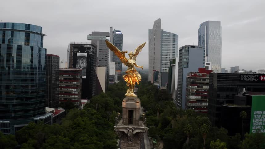 A gold statue sits in front of Mexico City