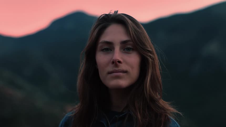 Portrait of a woman wearing a flannel shirt in a mountain region at dusk evening