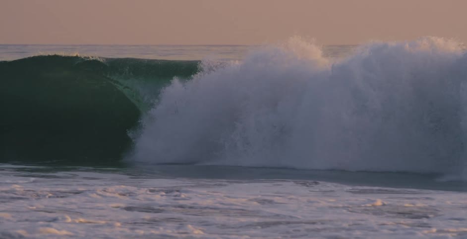 A person surfing in the ocean on large waves