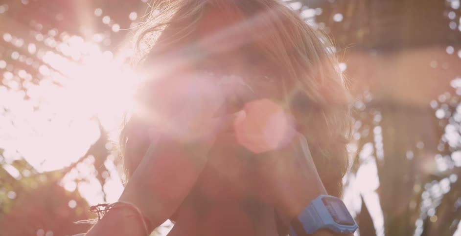 A boy spreads zinc oxide over his nose and cheek while in the glaring sun