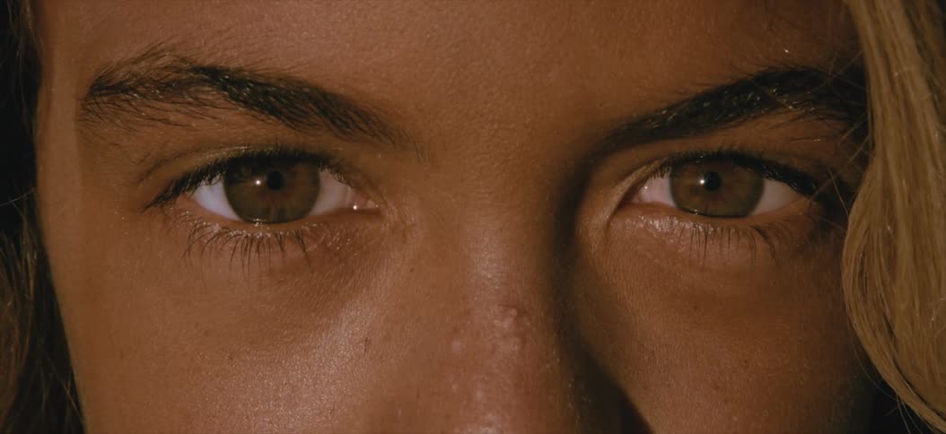 A close up of a teenage girl opening her eyes