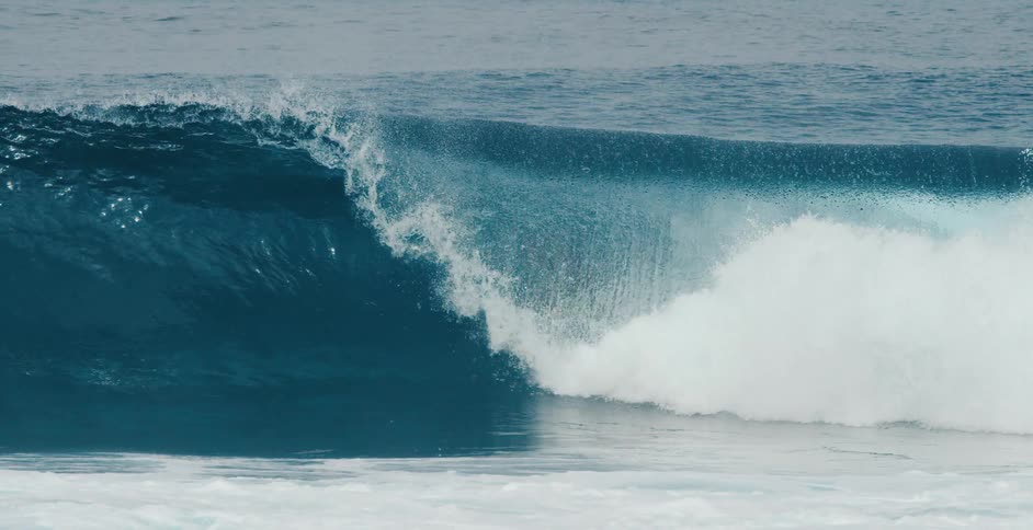 A surfer is riding a big wave as the water splashes overhead he stays on the surfboard