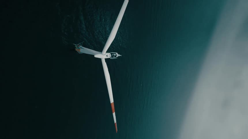 A wind turbine on the ocean on a cloudy day