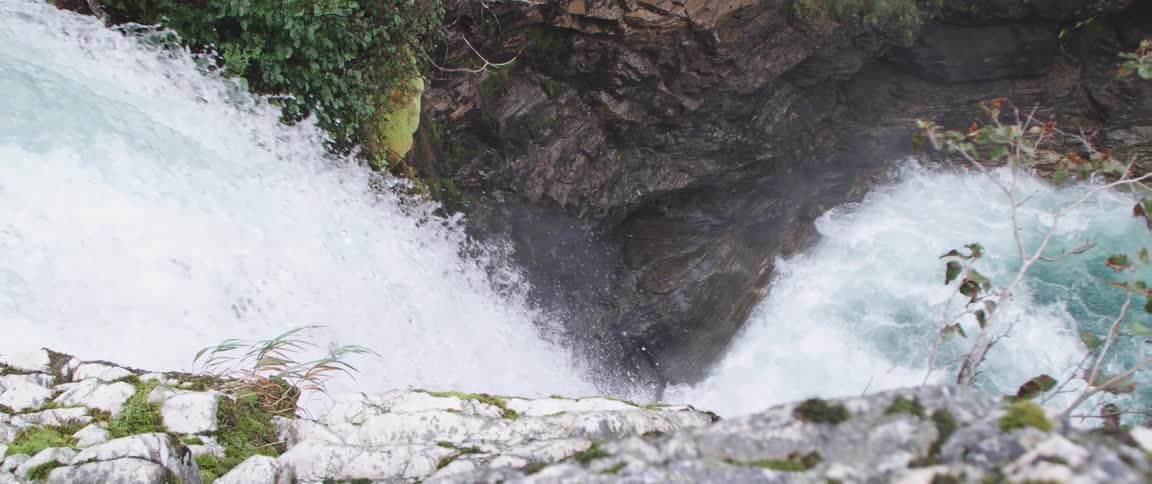 A waterfall down a cliff in the wilderness during the day