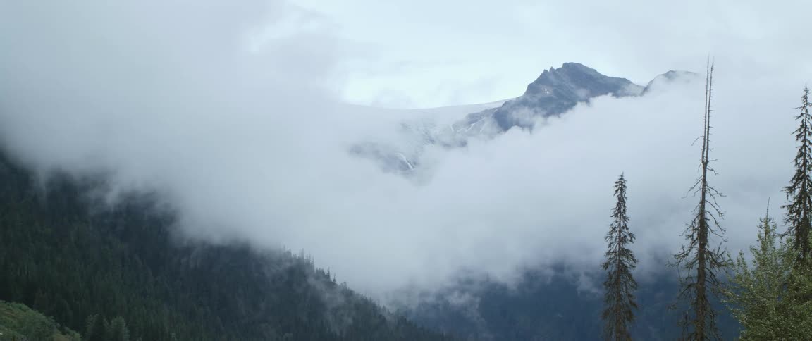 Aerial view of mountains in fog is displayed