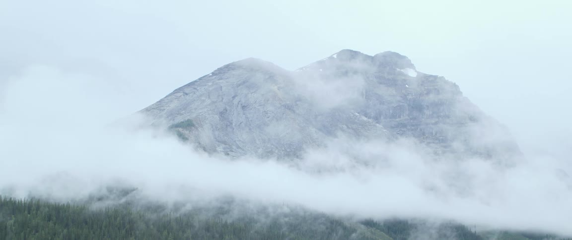 A mountain top peeks through dense clouds