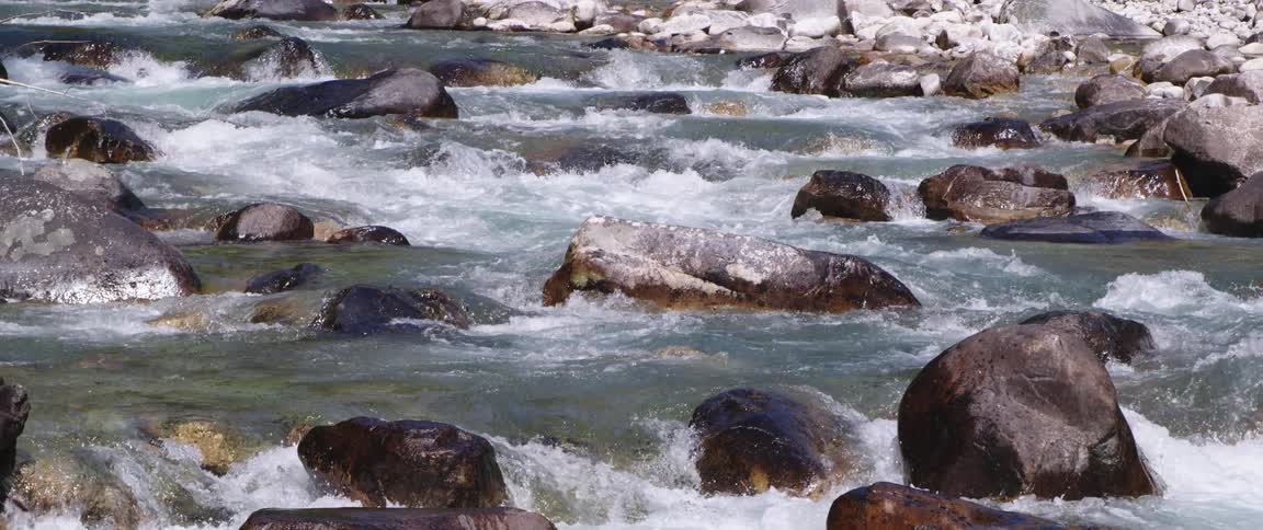 A water stream is flowing through the rock terrain