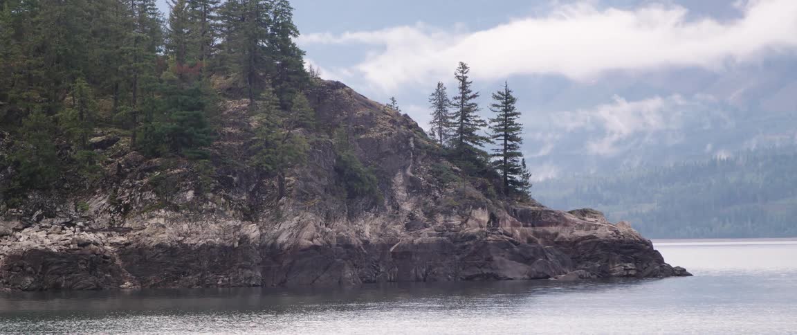 A view of a mountain on the edge of a lake outdoors
