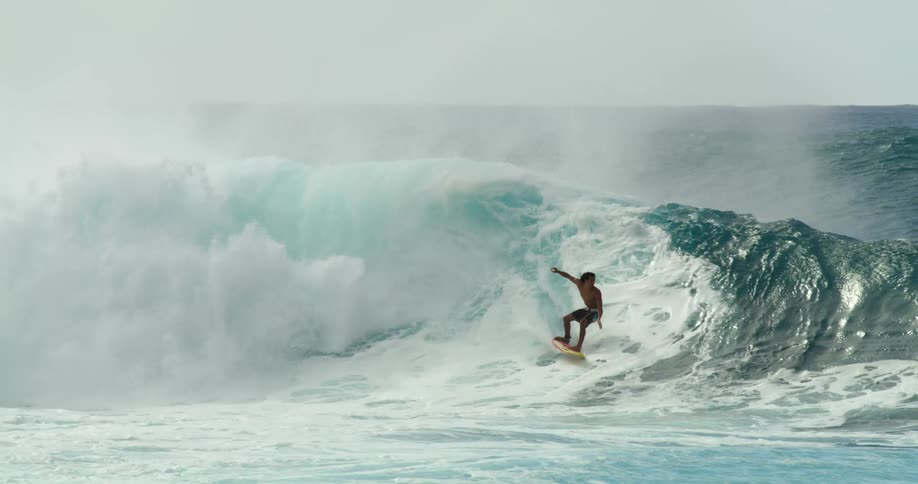 A surfer attempts to surf along a wave but is knocked airborne before falling into the ocean