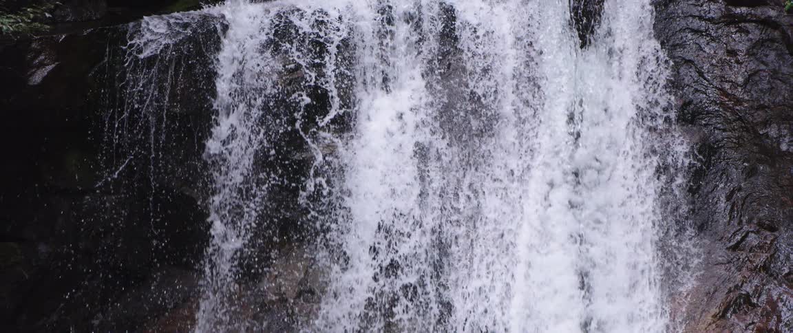 A waterfall down a rock face in the wilderness during the day